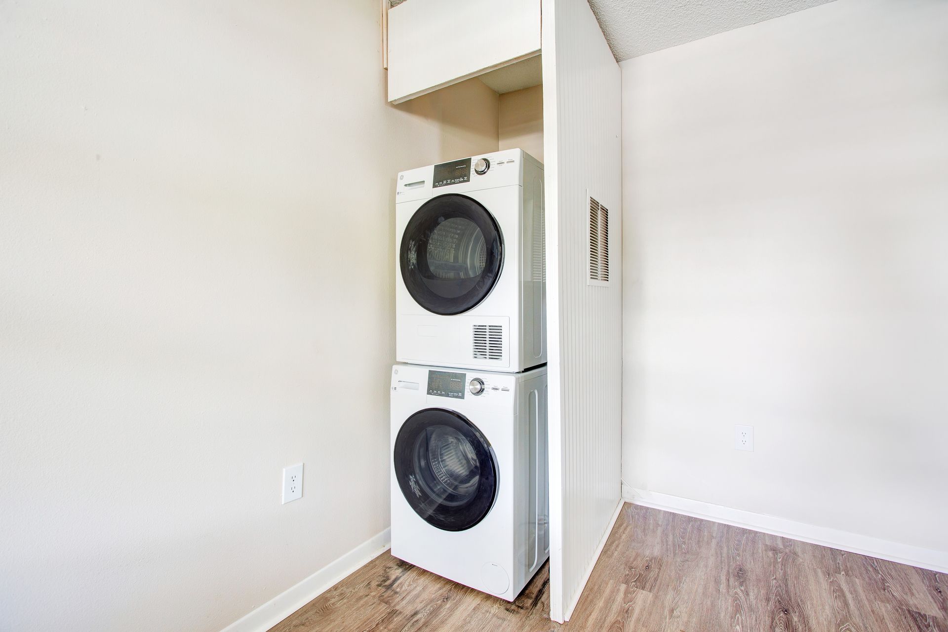 A washer and dryer are stacked on top of each other in a laundry room.