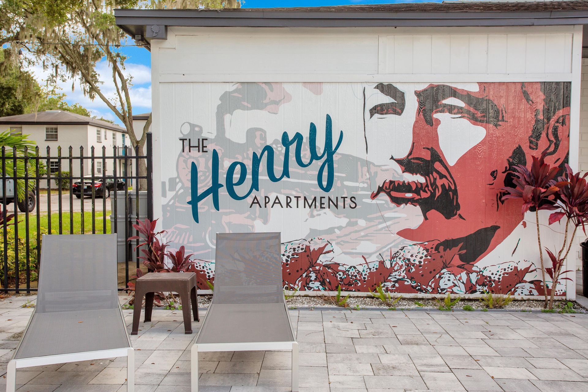 A mural of a man 's face is painted on the side of a building.