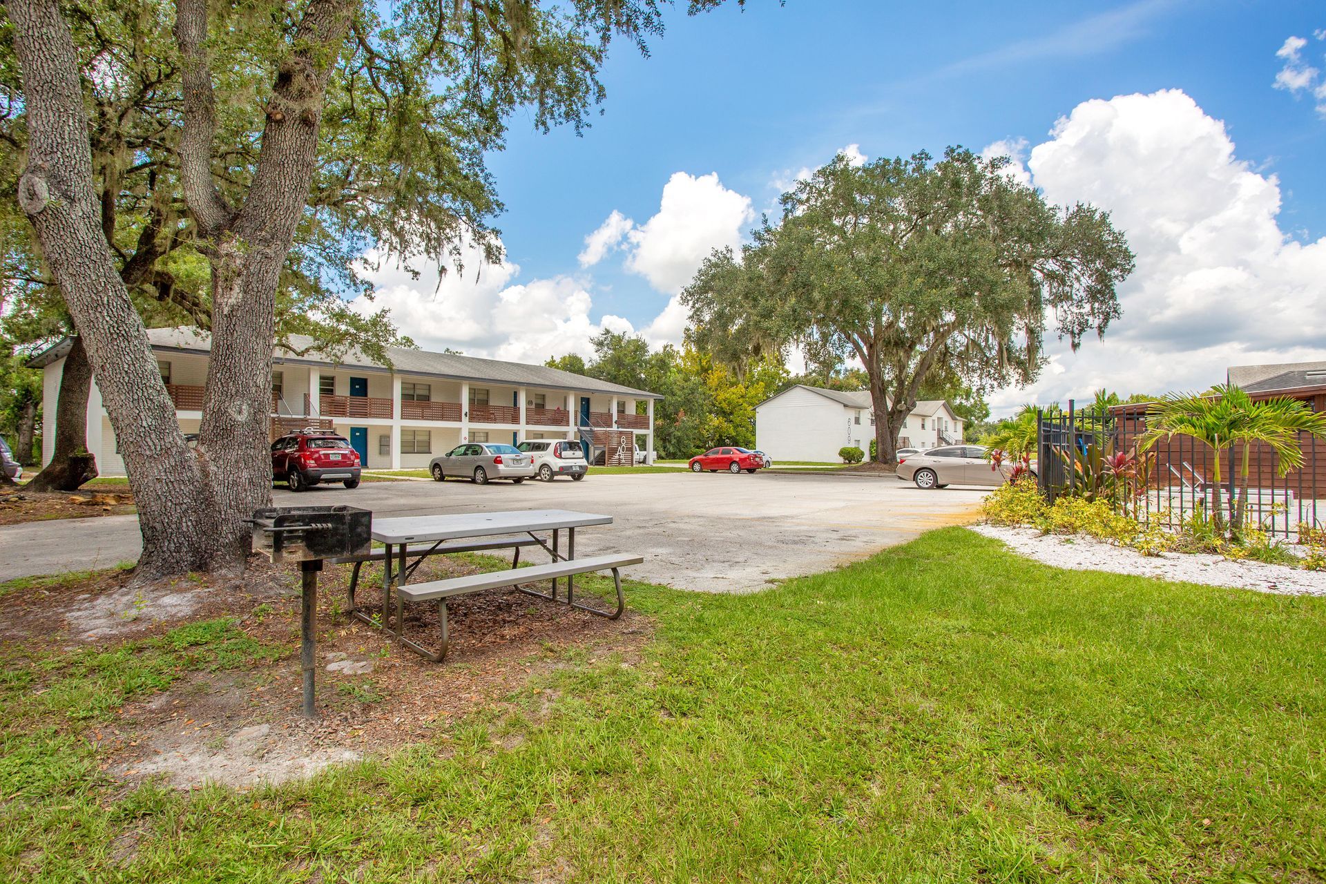 A picnic table is sitting in the grass in front of a building.