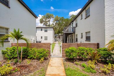 A white building with a wooden fence and a walkway leading to it.