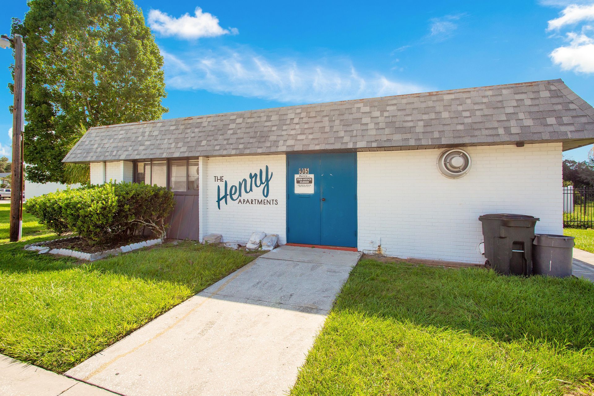 A white house with a blue door and the word henry on it