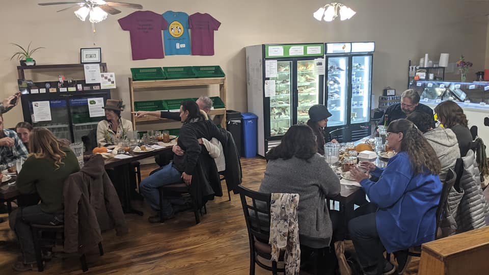 A group of people are sitting at tables in a restaurant.