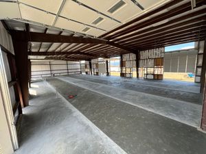 A tool smooths wet concrete into a level surface, transitioning from rough gravel to a flat, finished texture.