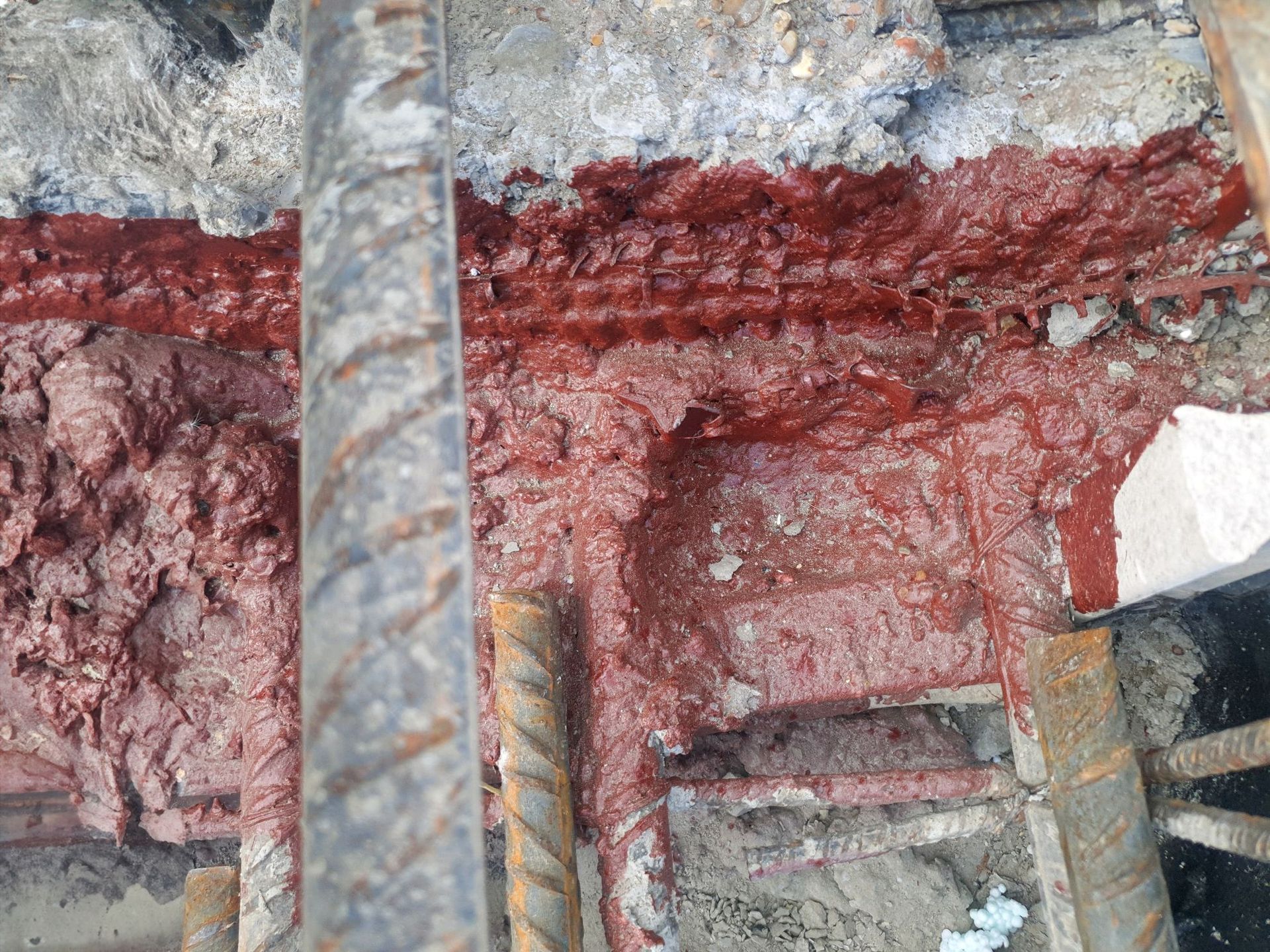 Woman in straw hat smiles, holding wine glass near a lake.