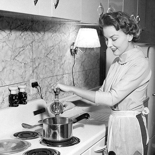 A black and white photo of a woman cooking