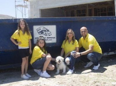 Photo of Affordable Dumpster Rental's team in front of a dumpster in Miami.