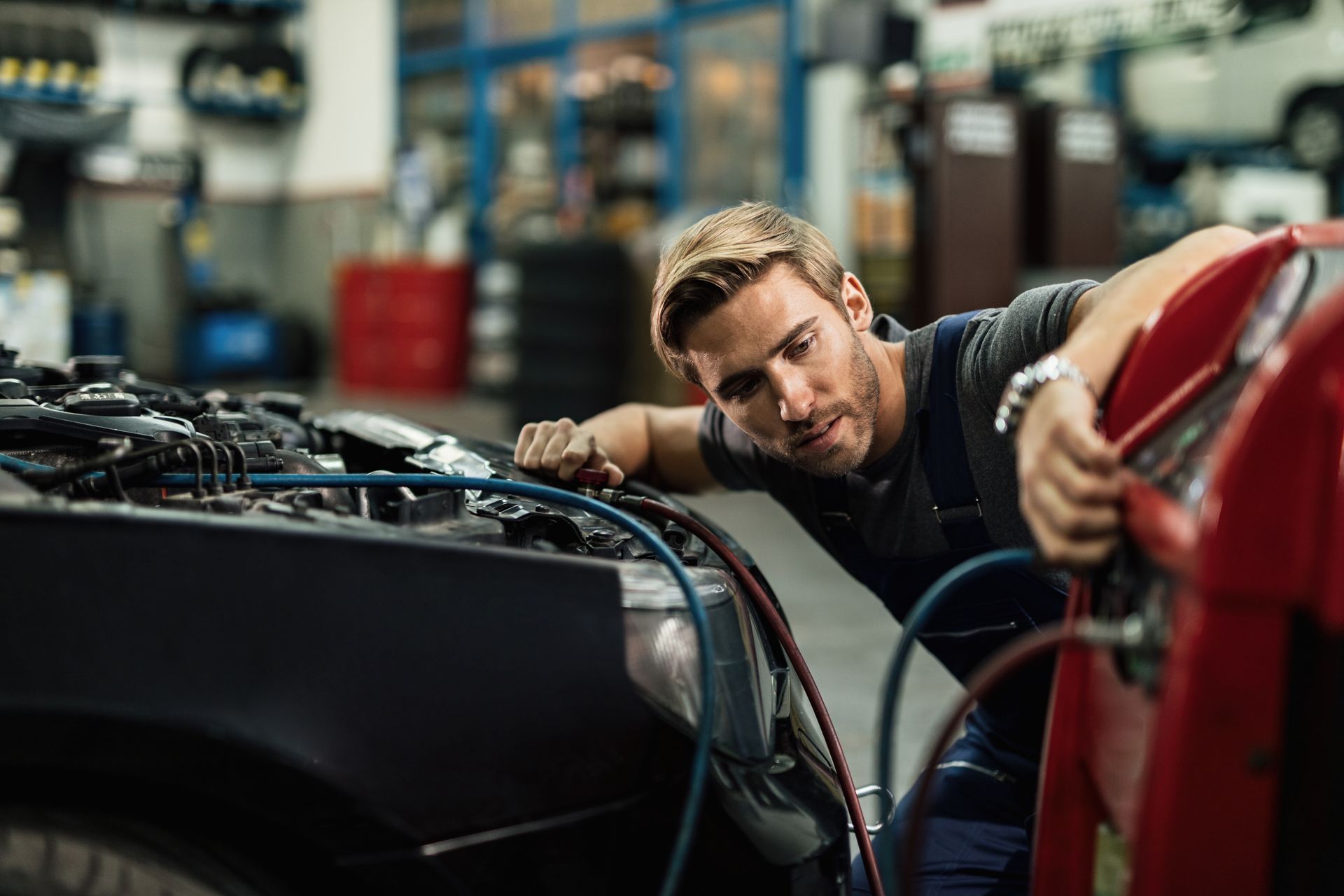 A man is working on a car in a garage.