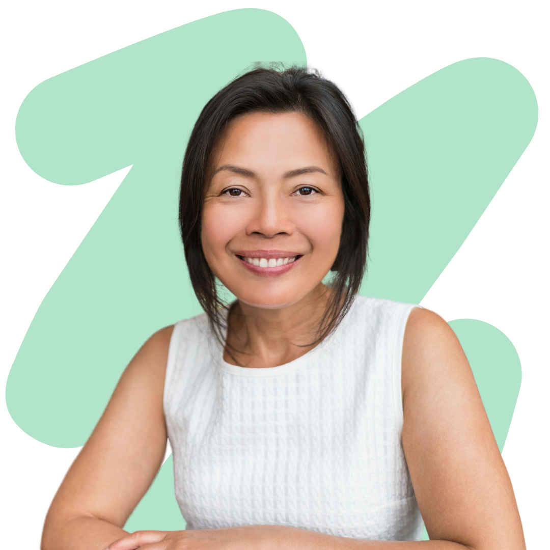 A woman in a white tank top is smiling in front of a green background.