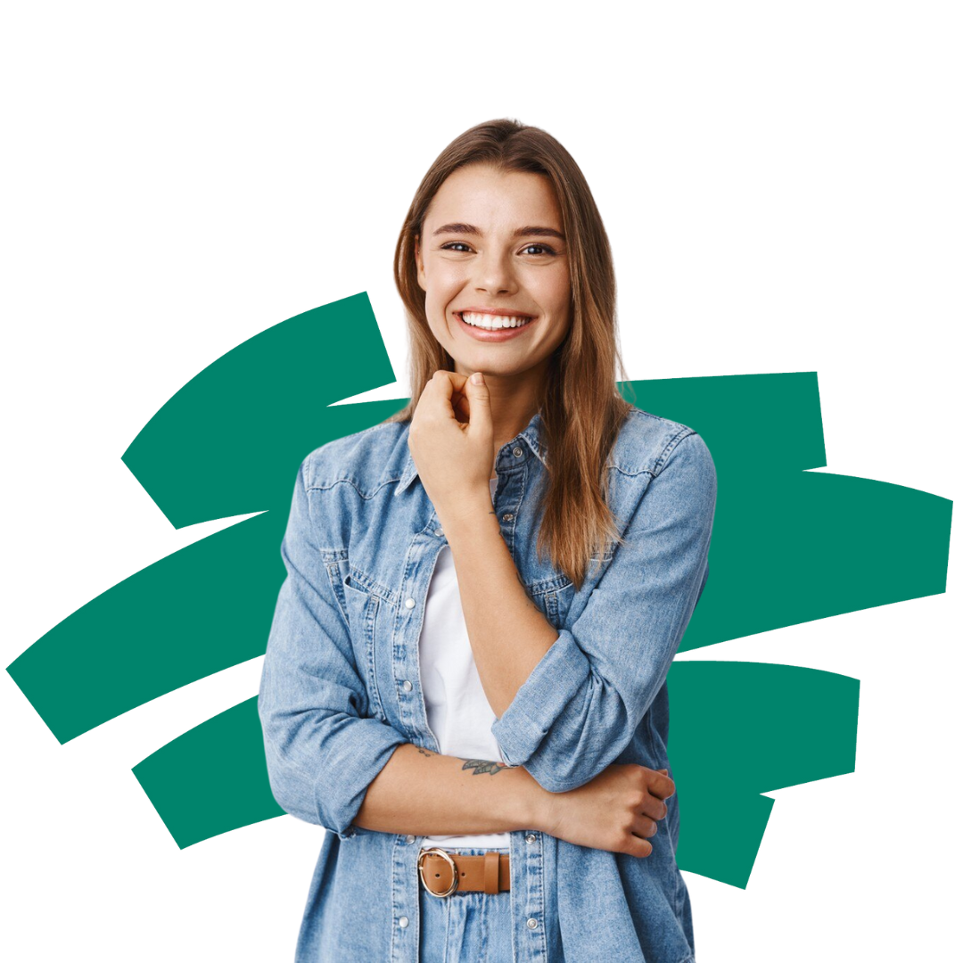 A woman in a denim shirt is smiling with her arms crossed.