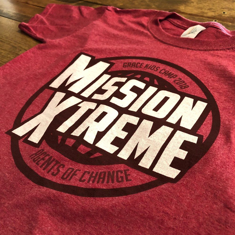 A red mission xtreme t-shirt is on a wooden table