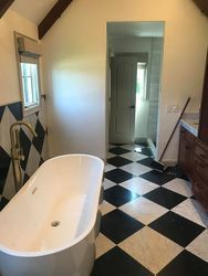 a bathroom with a bathtub and a checkered floor