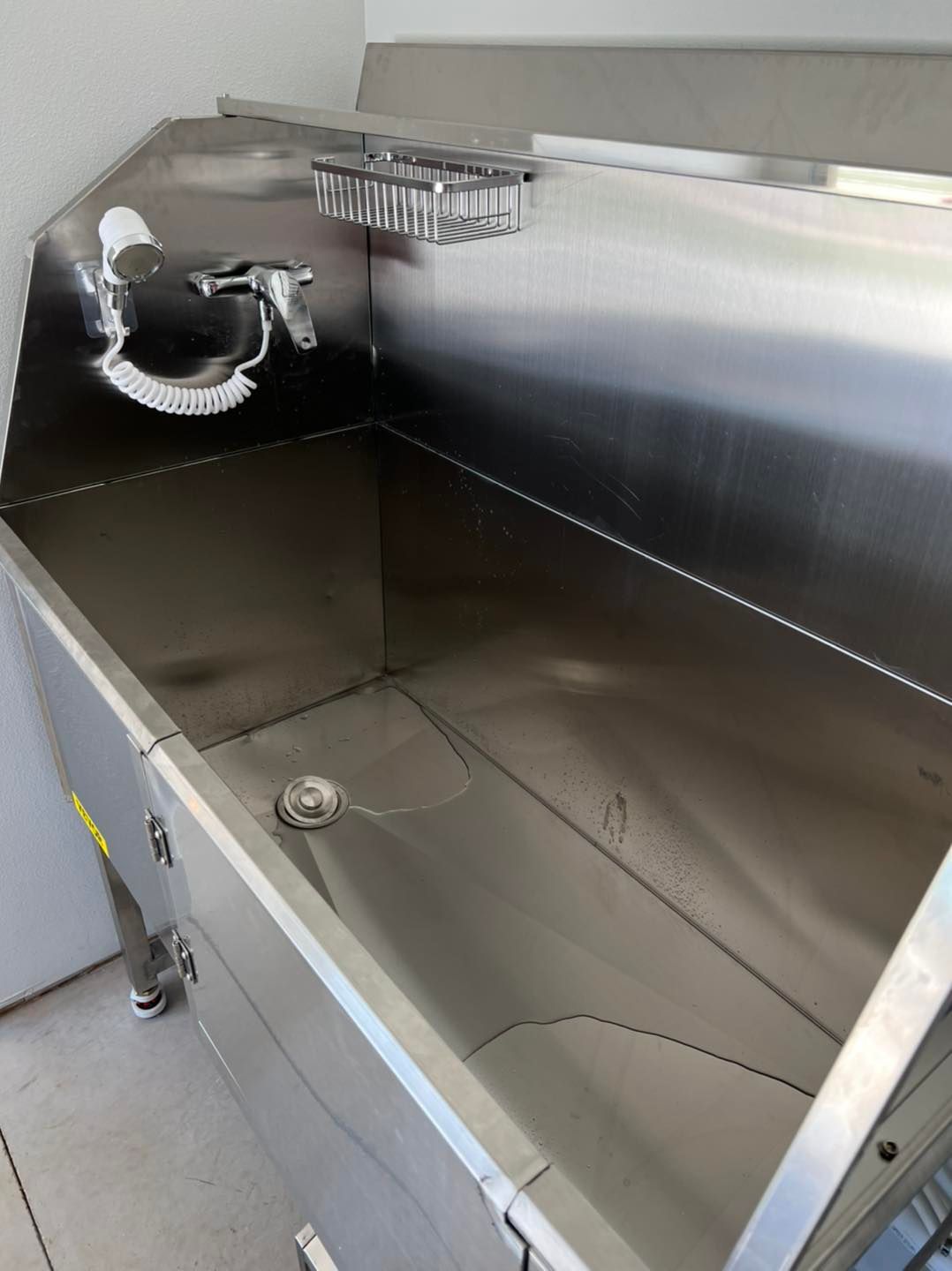 a stainless steel sink with a drain on the side