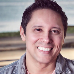 A man in a denim jacket is smiling for the camera