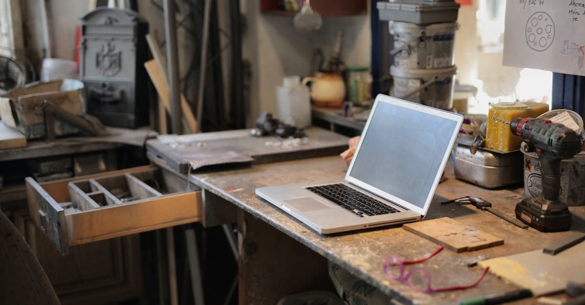 A laptop computer is sitting on top of a wooden table.