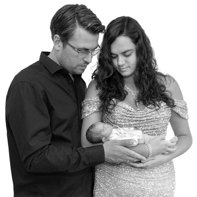 Een echtpaar houdt voorzichtig een pasgeboren baby vast en kijkt samen naar het kindje.