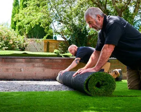 A man is installing a wooden deck with a drill.