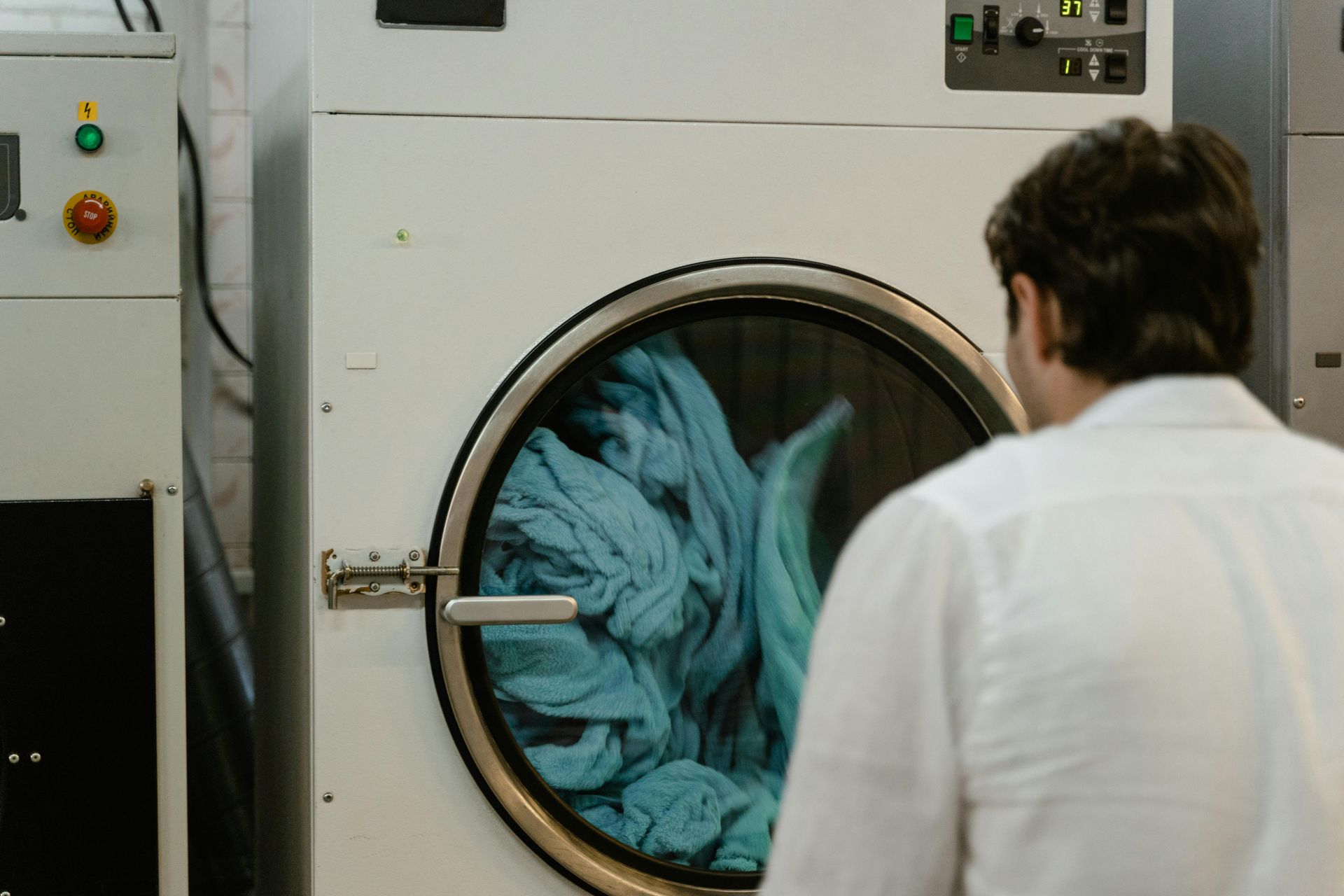 a man standing in front of a running clothes dryer