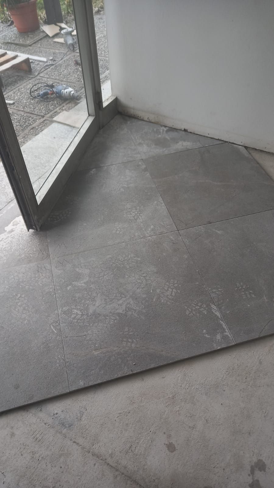 Pavimentazione in cemento all'interno di un edificio con un grande telaio di finestra visibile.