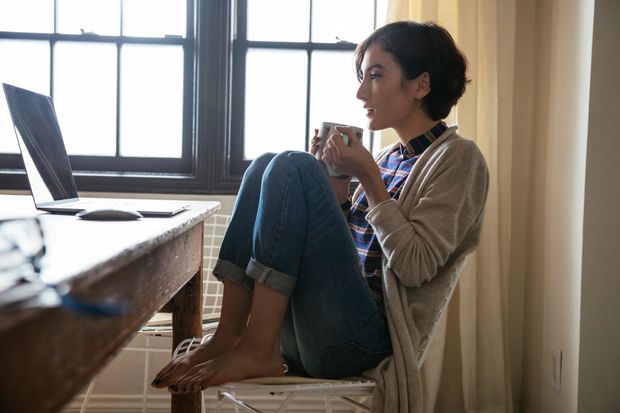 A girl is sitting at a desk using a laptop computer.