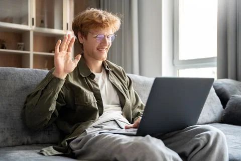 A tree with pink flowers is in front of a house.