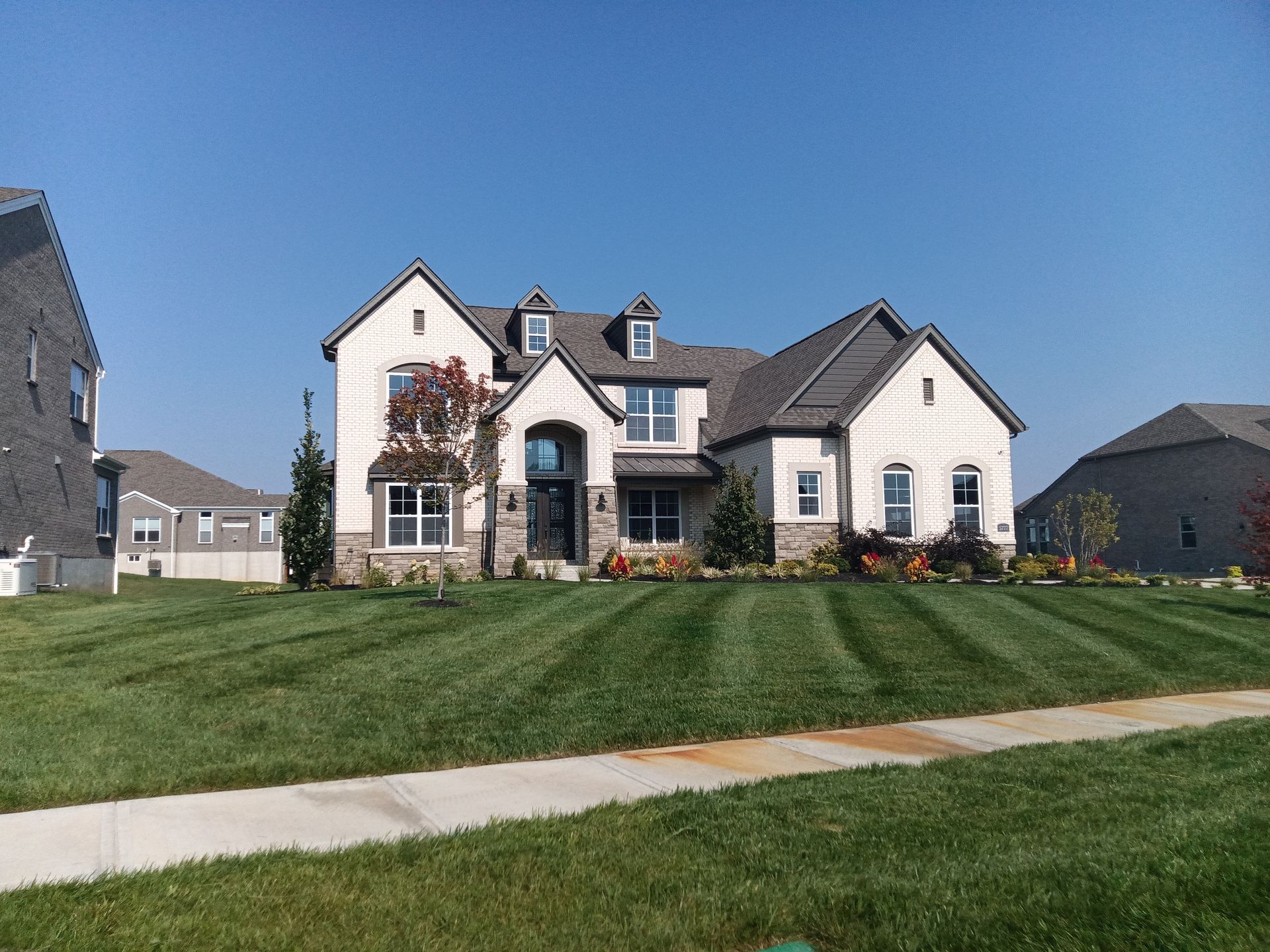 A Lush Green Lawn With A Black Edging And Gravel — Dayton, OH — Sharp Edge Landscaping And Lawncare LLC
