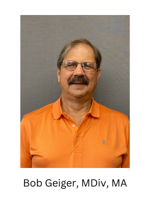 A man with a mustache and glasses is wearing an orange polo shirt.