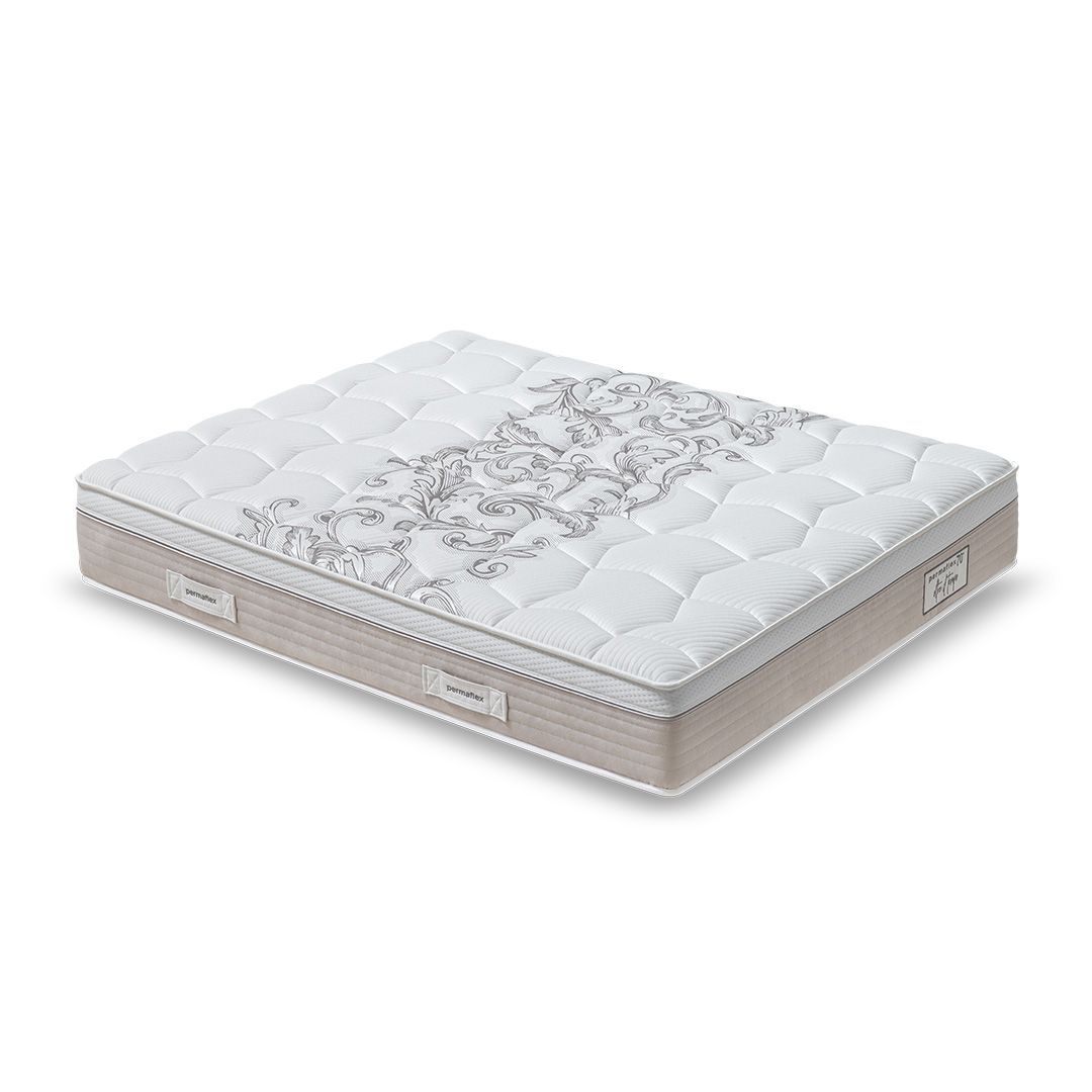 Materasso bianco e beige con superficie trapuntata e motivo floreale sulla parte superiore.