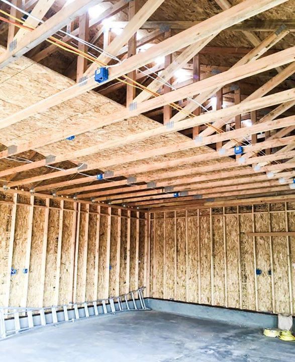 A garage under construction with wooden beams and a ladder.