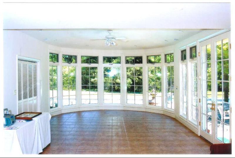 A room with a lot of windows and a ceiling fan