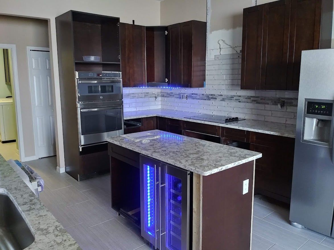 A kitchen with a large island and a refrigerator.