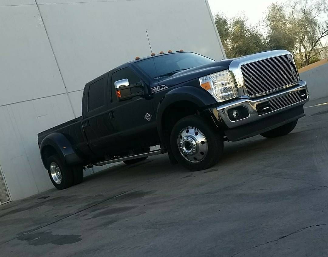 A black truck is parked in front of a white building