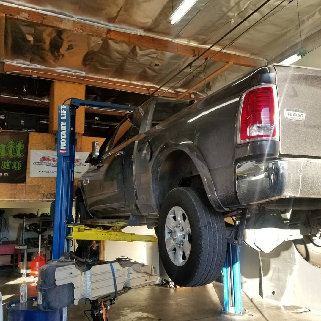 A ram truck is on a lift in a garage