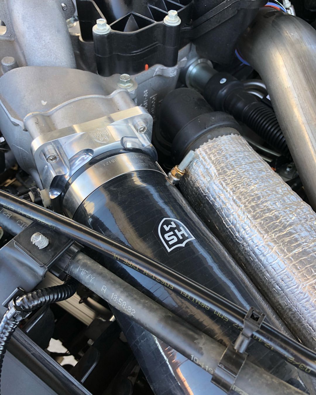 A close up of a car engine with a hose that says u.s.a. on it