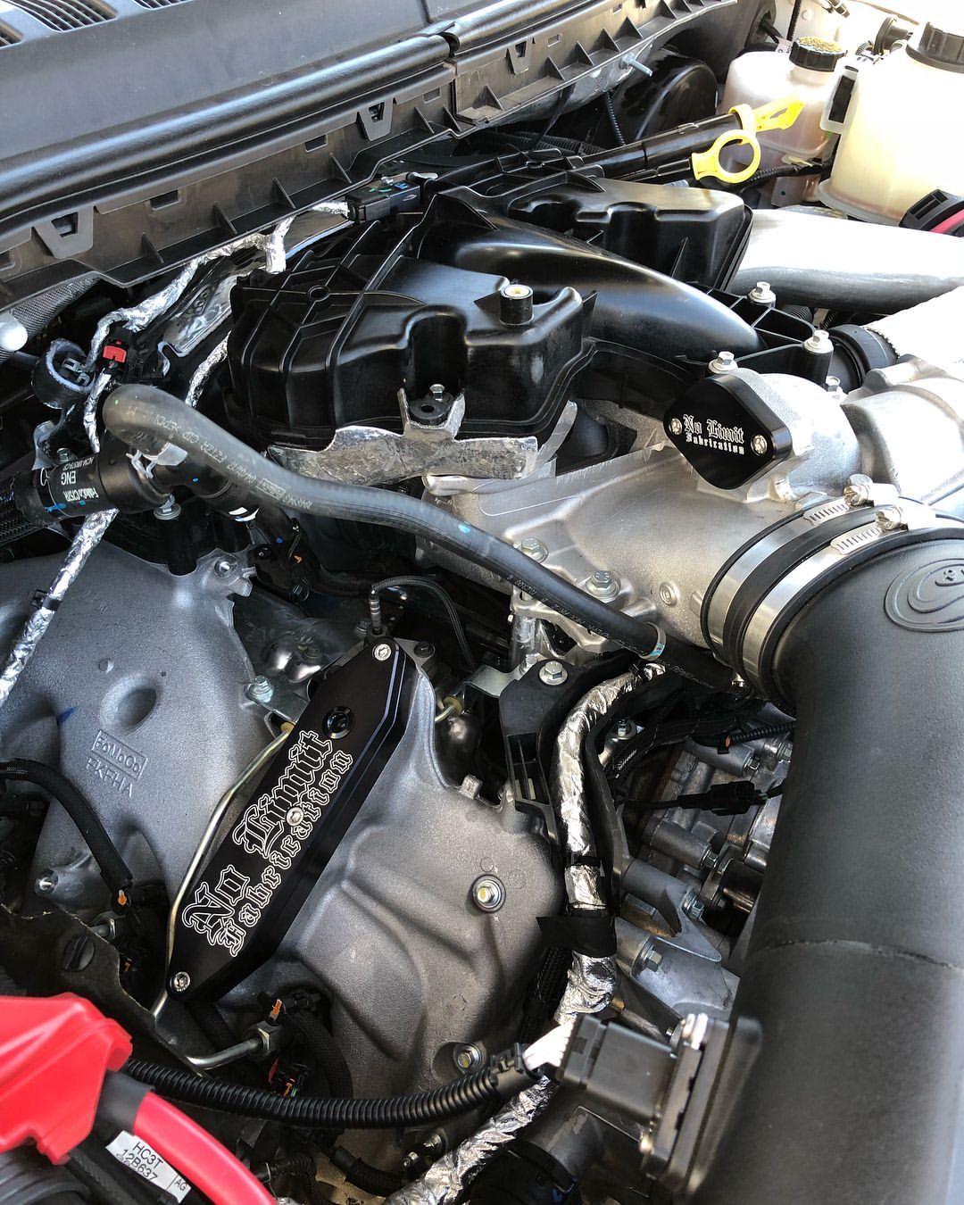 A close up of a car engine with the hood open.