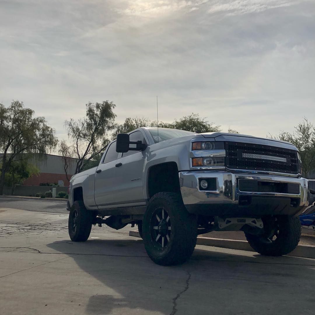 A silver truck is parked in a parking lot.