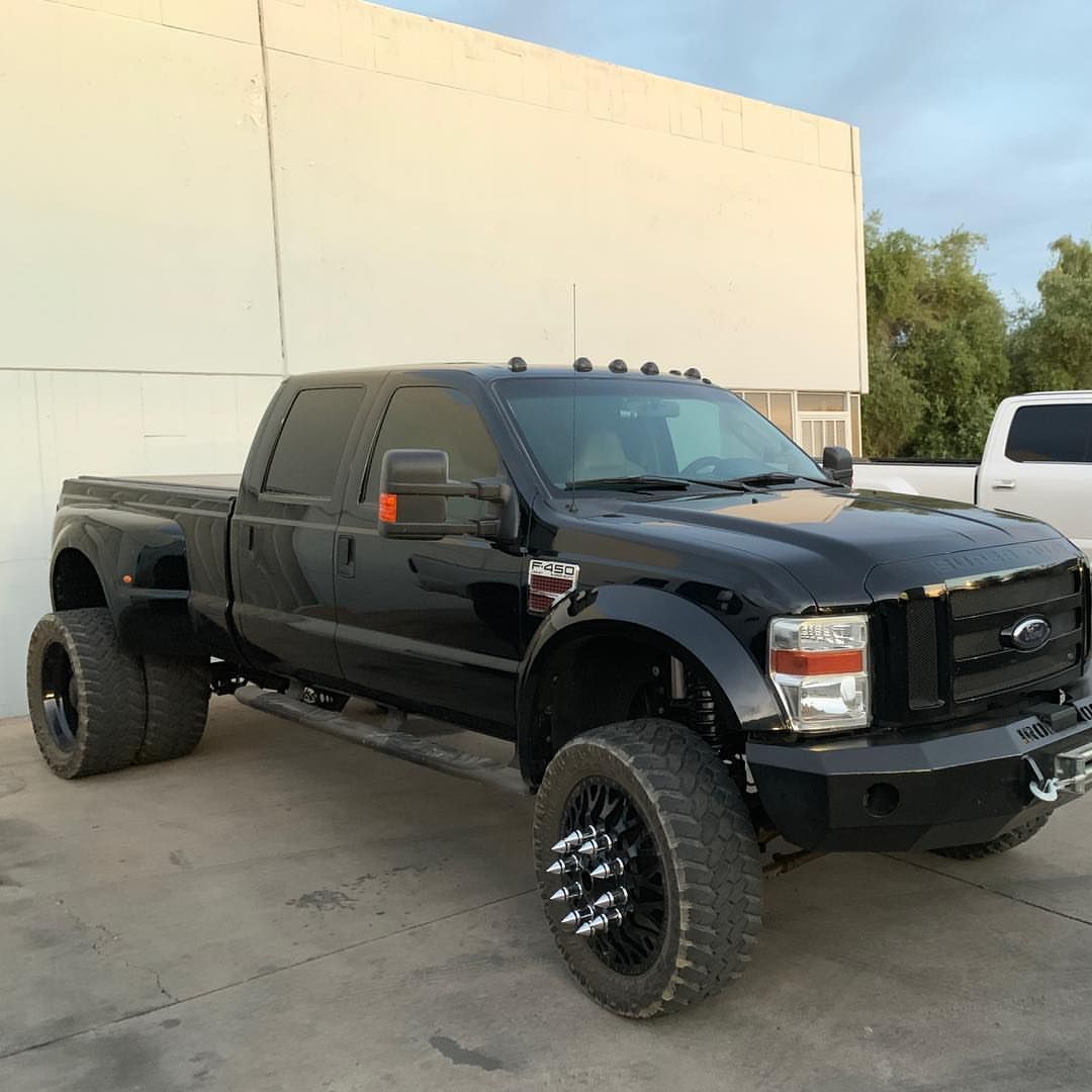 A black truck is parked in front of a building.