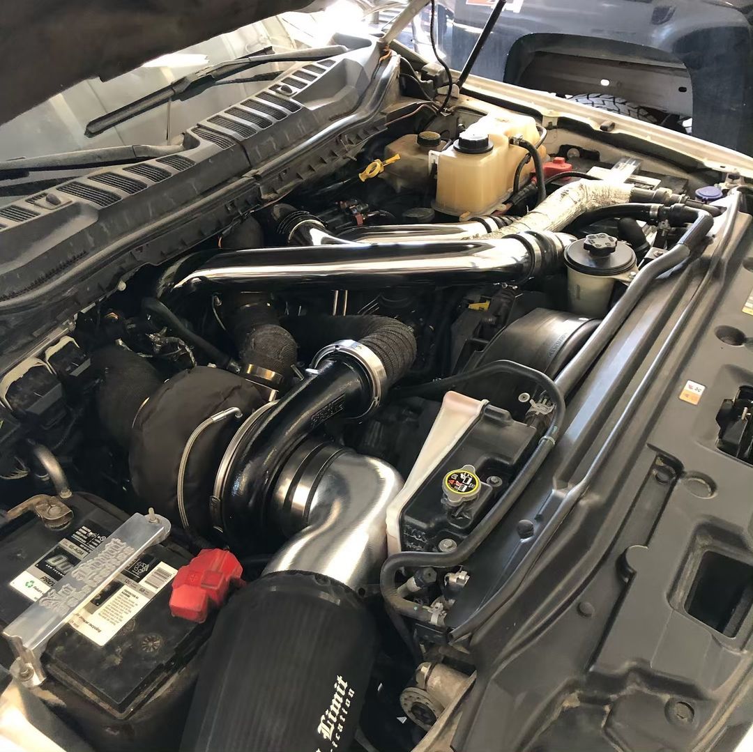 A close up of a car engine with the hood open