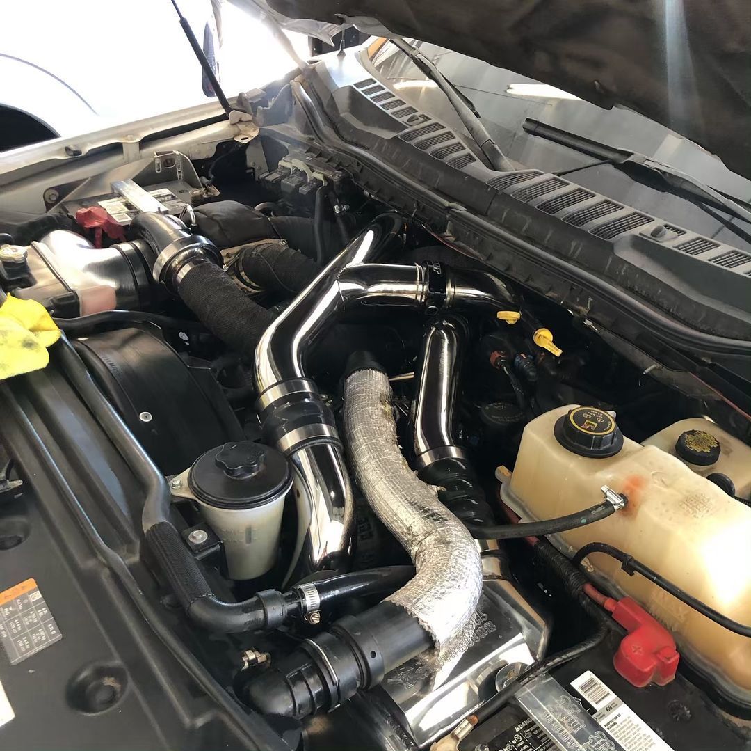 A close up of the engine of a car with the hood open.