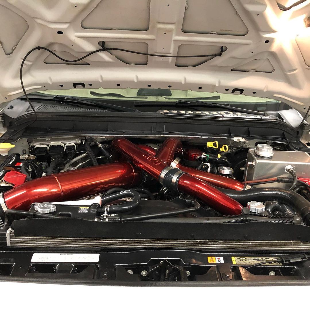 A close up of a car engine with the hood open