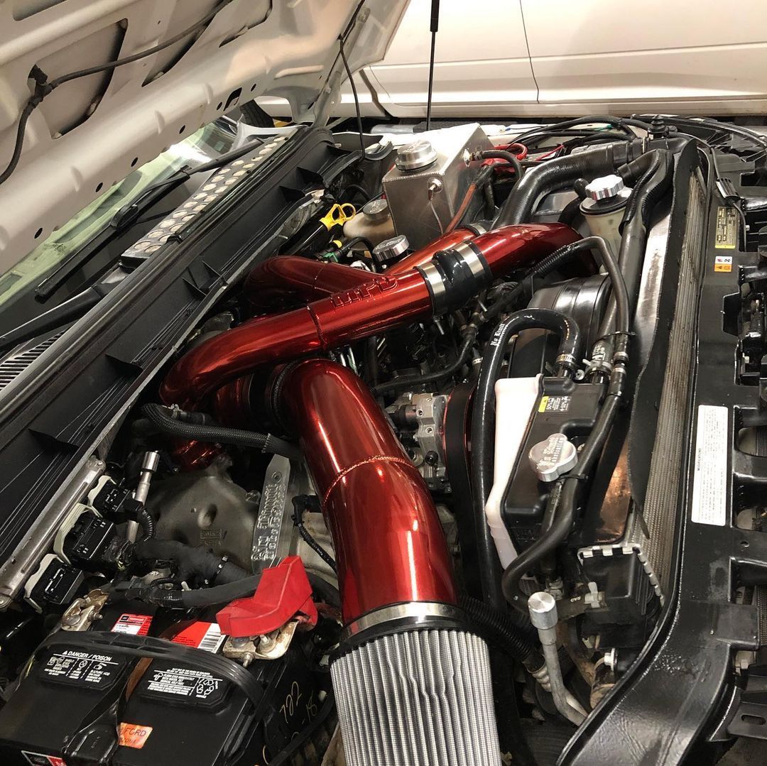 A close up of a car engine with the hood up