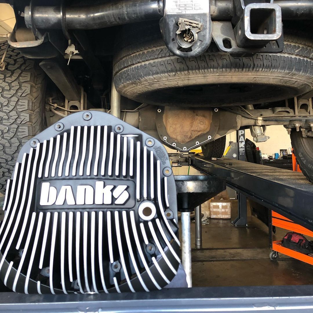 A bank 's differential cover is sitting on the back of a truck.