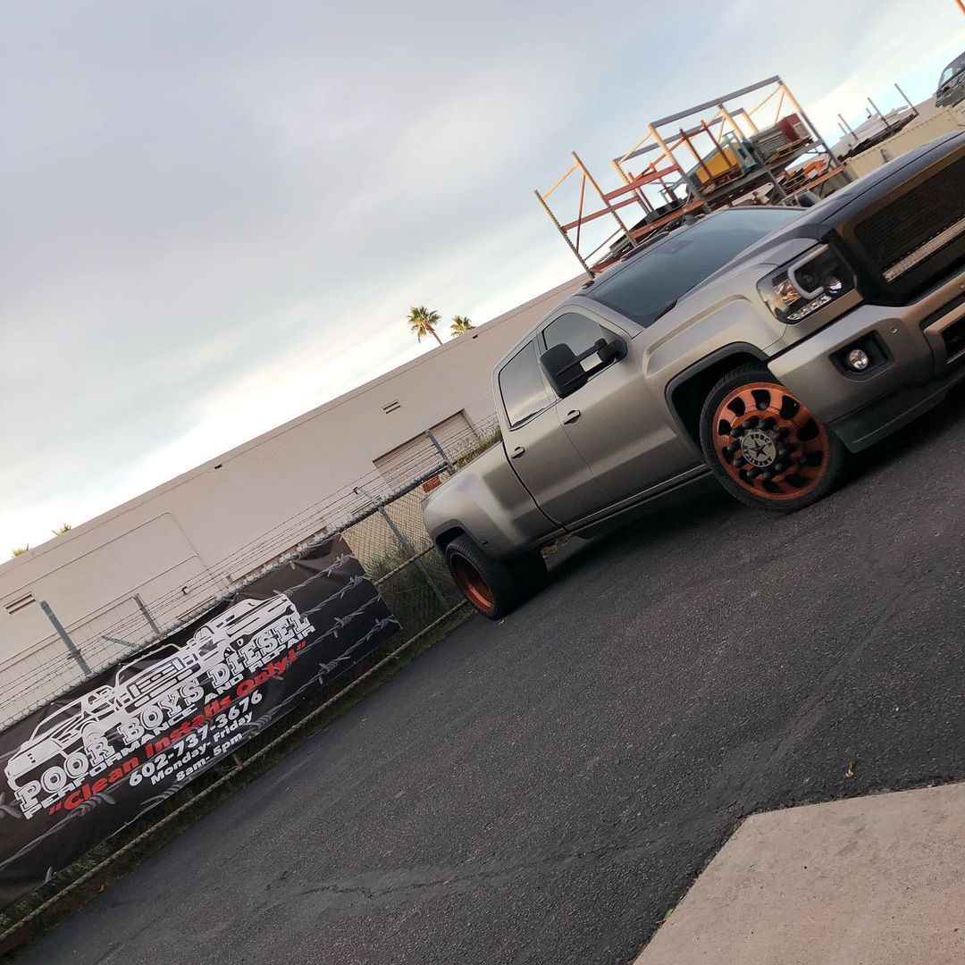 A silver truck is parked in a parking lot next to a building