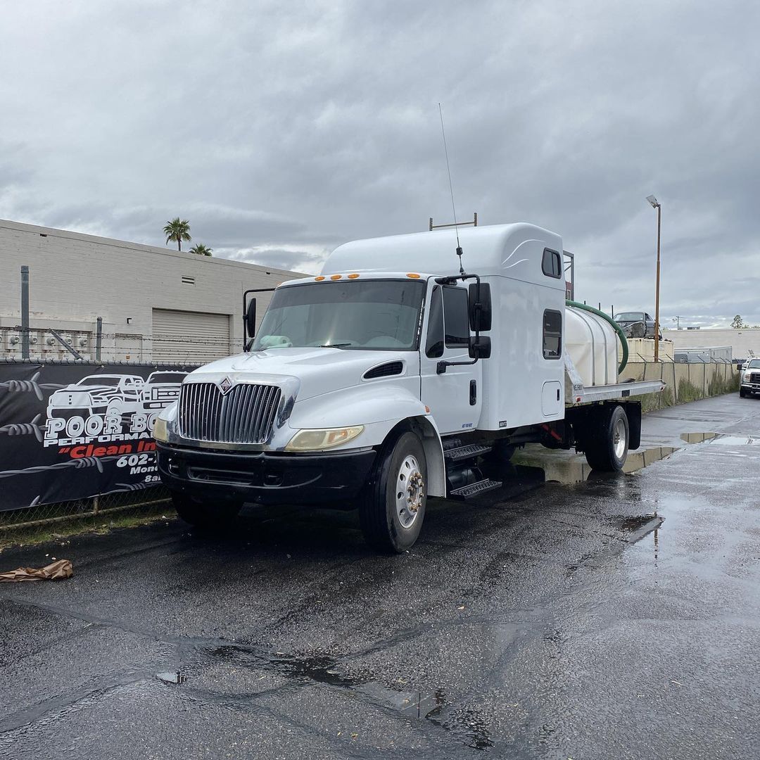A white semi truck is parked on the side of the road.