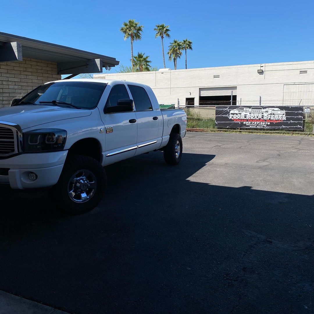 A white truck is parked in front of a building