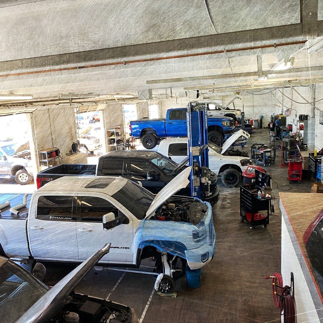 A lot of cars are being worked on in a garage.