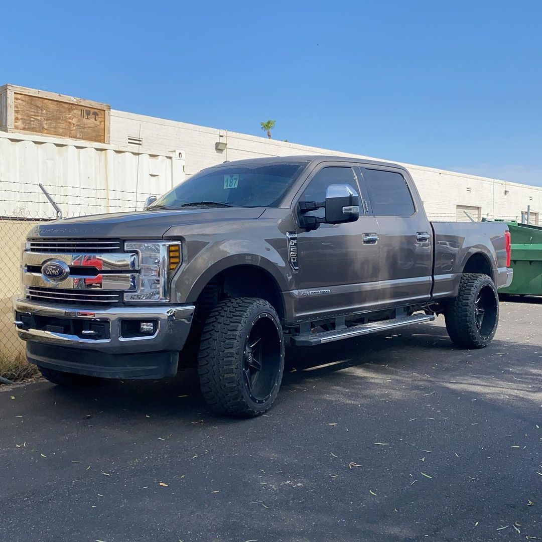 A gray pickup truck is parked in front of a building.