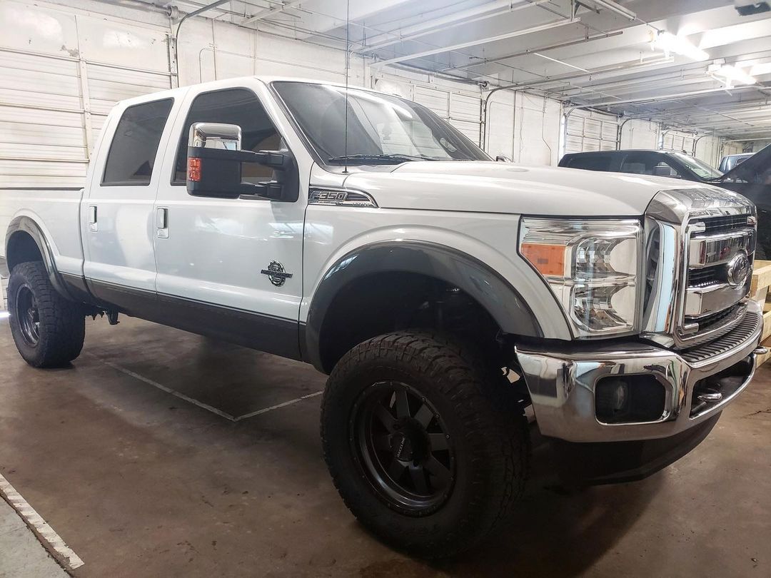 A white pickup truck is parked in a garage.