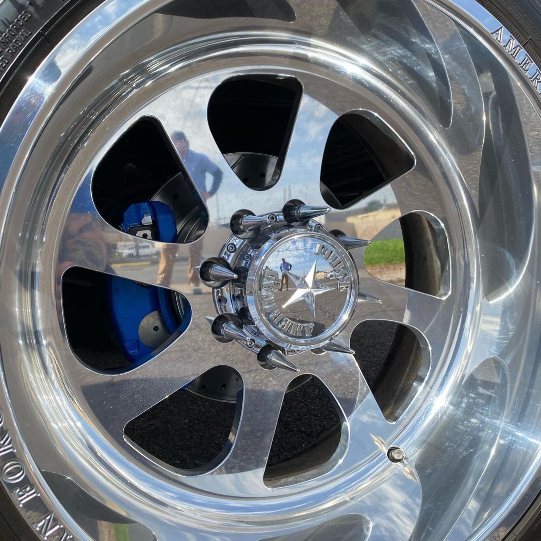 A close up of a chrome wheel on a car