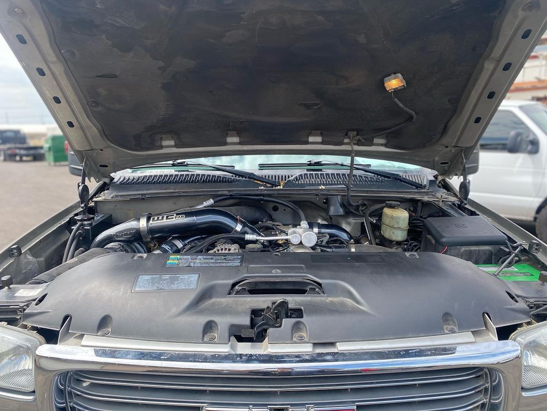The hood of a truck is open and the engine is visible.