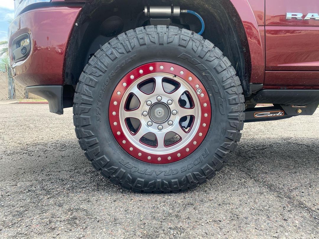 A close up of a red truck with a red rim and tire.